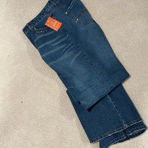 Mid wash Fashion jeans with grommet detaining and a flair bottom edge